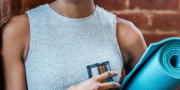 A rolled-up yoga mat and a water bottle, ready for a session.